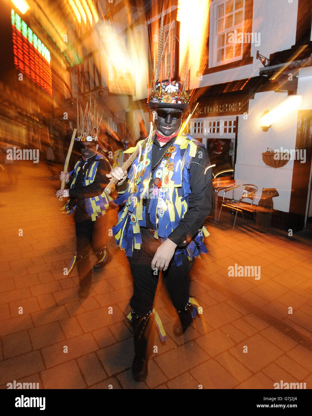 Mitglieder der Hook Eagle Morris-Tänzer tanzen vor dem Wagon and Horses Pub, nachdem sie nach einem 'Wassail' in Hartley Wintney, Hampshire, vom Vaughan Millennium Apple Orchard zurückgekehrt sind. Stockfoto