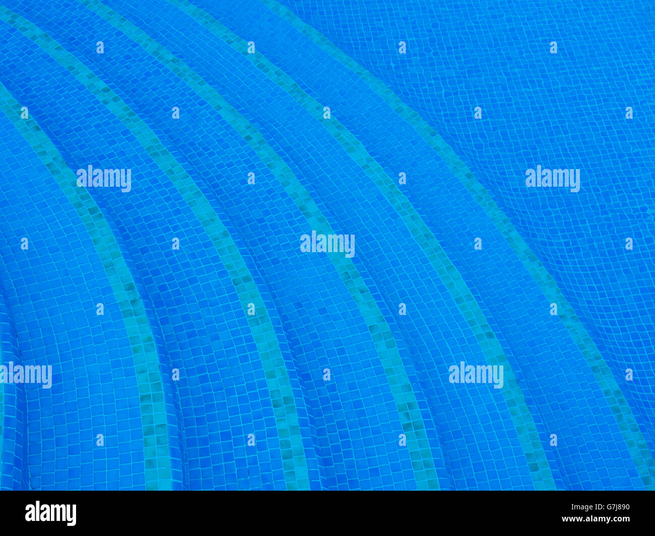 Abstraktes Bild blau Schwimmbadwasser, Fliesen und geschwungene Treppe Stockfoto