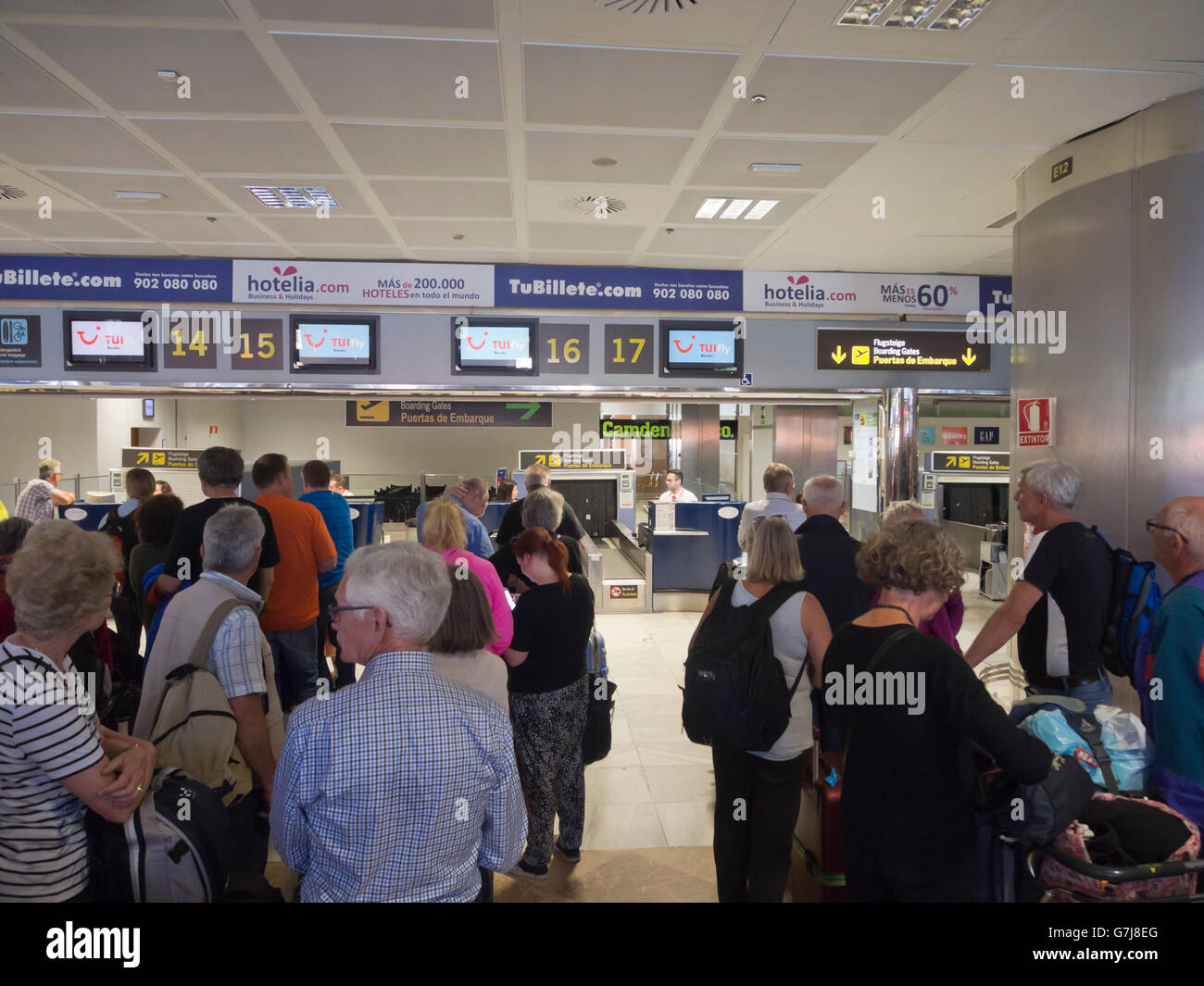 Checken Sie sich lange Zeilen in einem spanischen Flughafen (Reina Sofia), Touristen auf dem Weg nach Hause von einem Urlaub auf Teneriffa Stockfoto