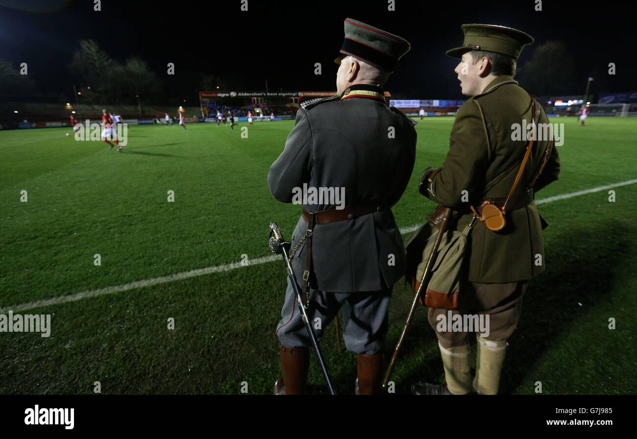 Zwei Schauspieler, die in Uniformen des Ersten Weltkriegs gekleidet sind, sehen sich das Weihnachts-Waffenstillstandsspiel des Ersten Weltkriegs im Electrical Services Stadium, Aldershot, an. Stockfoto