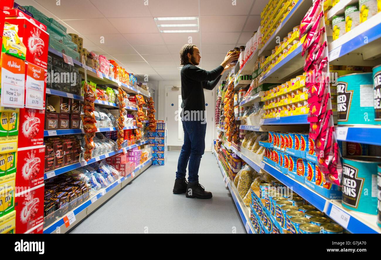 Der Gemeinschafts-Supermarkt verkauft überschüssige Lebensmittel. Ein Mitarbeiter hat Regale im Community Supermarket im Westen von Norwood, im Süden von London, auf Lager. Stockfoto