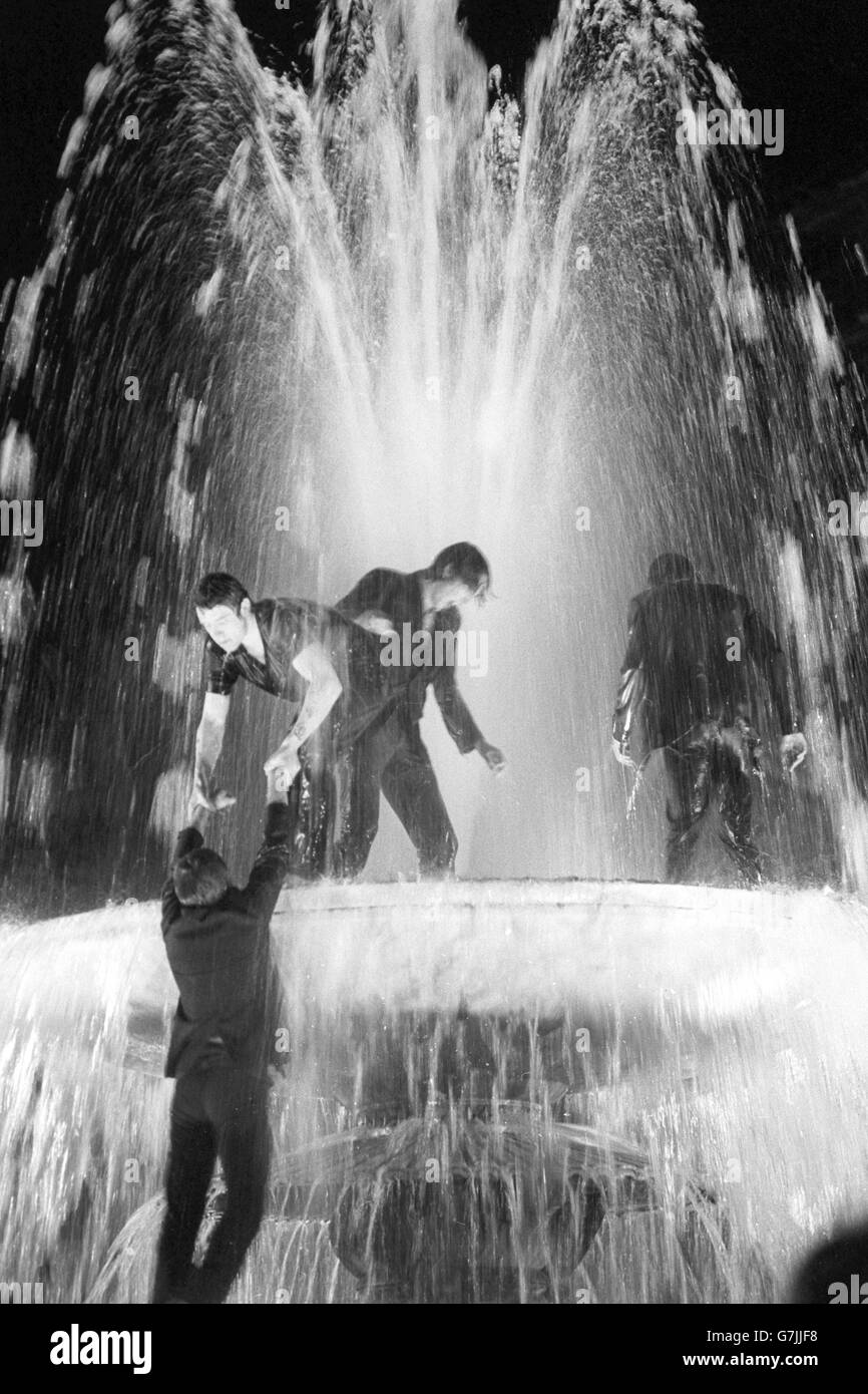 Die Leute springen in die Brunnen am Trafalgar Square, während eine Menge auf einem riesigen Fernsehbildschirm auf die Wahlergebnisse wartet. Stockfoto