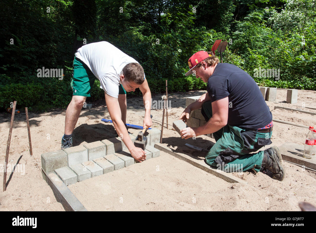 Bürgersteig Arbeitnehmer einen Pfad Kopfsteinpflaster. Stockfoto Bürgersteig Arbeitnehmer einen Pfad Kopfsteinpflaster. Stockfoto