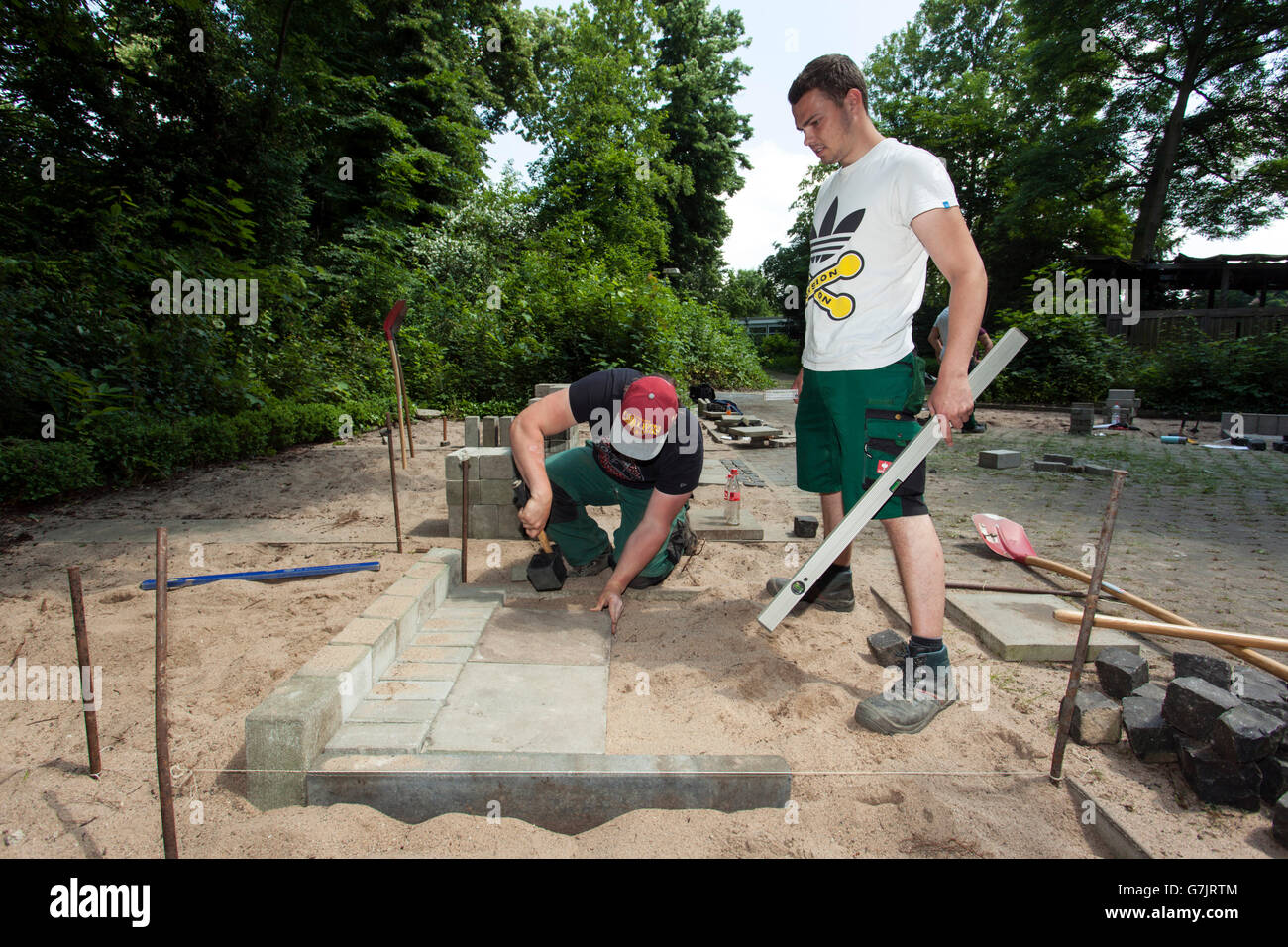 Bürgersteig Arbeitnehmer einen Pfad Kopfsteinpflaster. Stockfoto Bürgersteig Arbeitnehmer einen Pfad Kopfsteinpflaster. Stockfoto