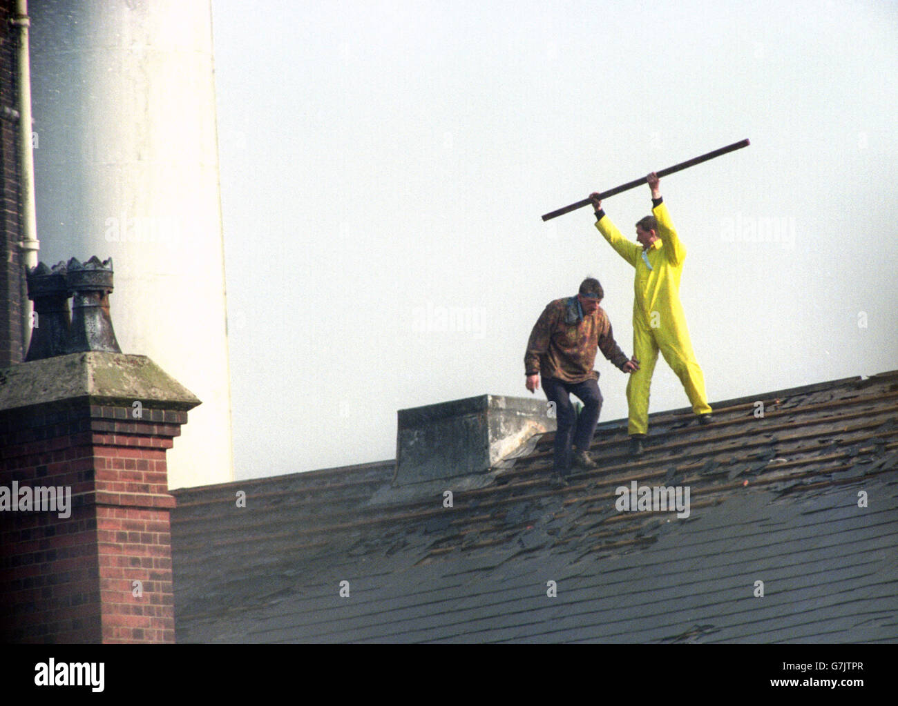 Zwei Gefangene zeigten sich immer noch trotzend gegenüber der Verfolgung von Gefängnisbeamten, nachdem sie auf das Dach des Gefängnisses Strangeways getrieben wurden. Stockfoto