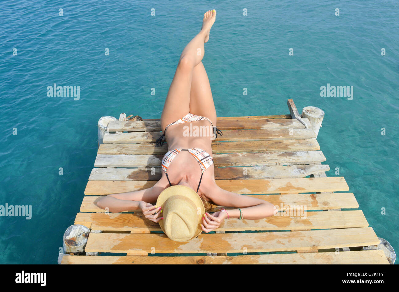 Frau im Bikini auf dem Dock liegen. Sommerurlaub Stockfoto