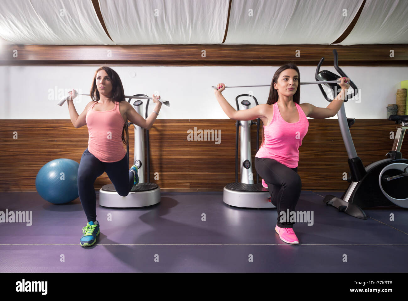 Passen zwei junge Frauen Bewegung, ein Bein Longe Widerstand Band, Fitness-Studio Stockfoto