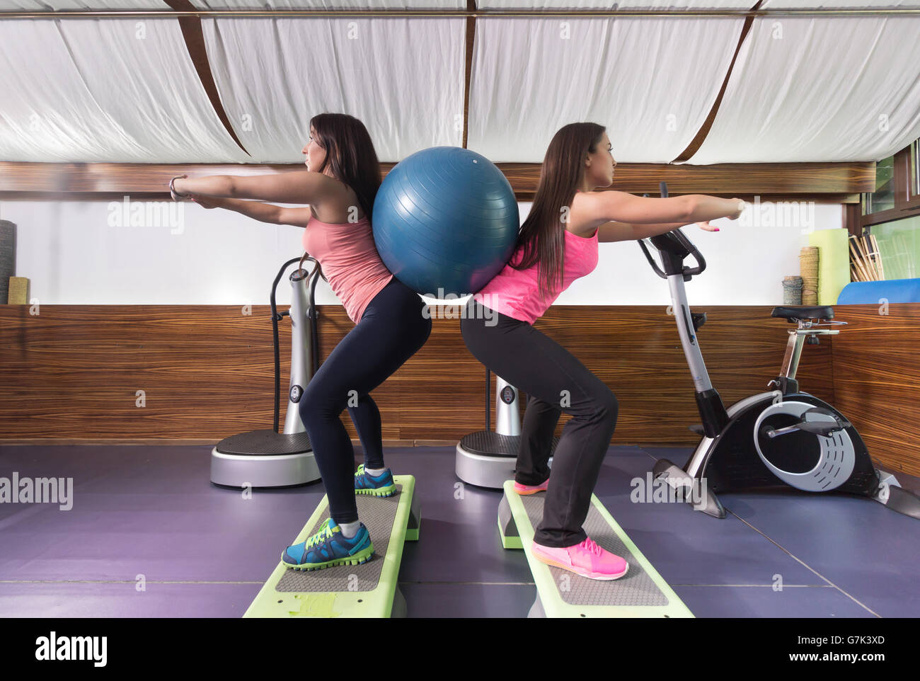 Zwei Frauen Gym Übung Kugel Rücken. Seitenansicht. Stockfoto