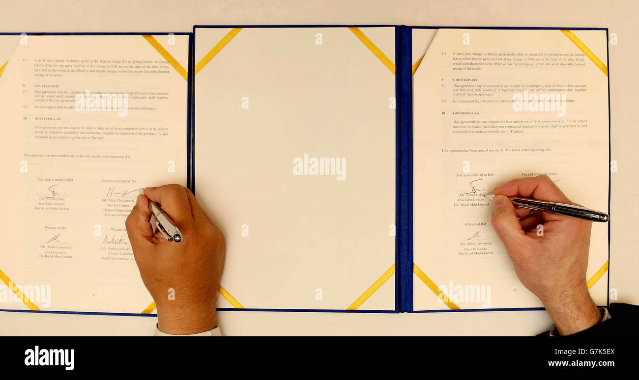 Simon Lake (rechts), Verkaufsdirektor der Royal Mint, und Dr. Naris Chaiyasoot (links), Generaldirektor des Treasury Department, Thailand, an der Royal Thai Embassy London für die Unterzeichnung eines Abkommens über technische Zusammenarbeit (TCA) zwischen der Royal Mint und dem Treasury Department of Thailand. Stockfoto