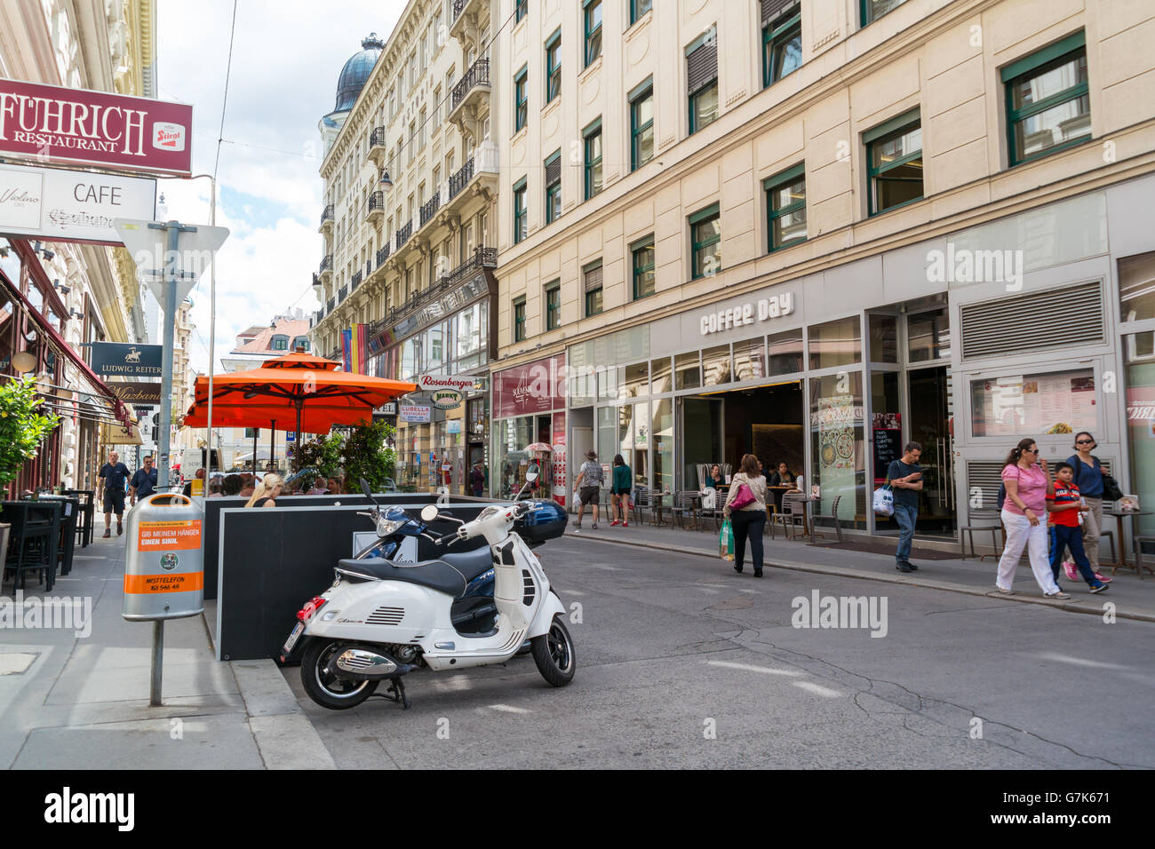 Straßenszene von Tegetthoffstrasse mit Menschen, Kaffeehaus, Scooter und Freiluft-Café in der Innenstadt von Wien, Österreich Stockfoto