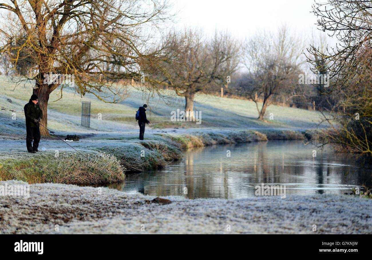 Fischer versuchen ihr Glück an den frostigen Ufern des Flusses Cam bei Granchester Meadows in Cambridgeshire. Stockfoto