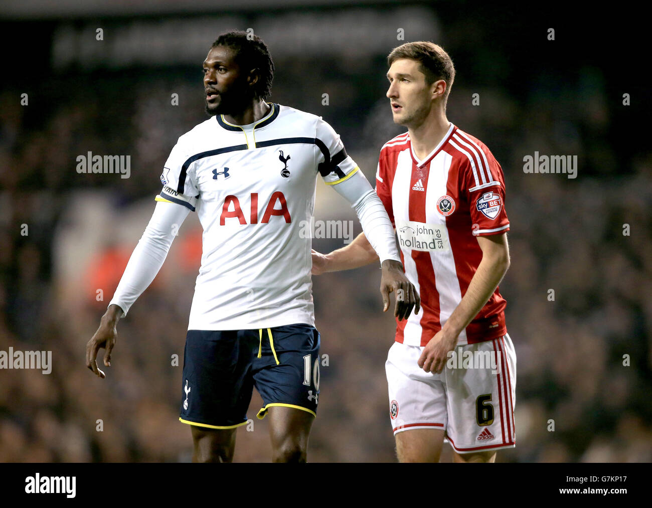 Emmanuel Adebayor von Tottenham Hotspur (links) und Chris Basham von Sheffield United während des Capital One Cup Halbfinales, First Leg in der White Hart Lane, London. Stockfoto