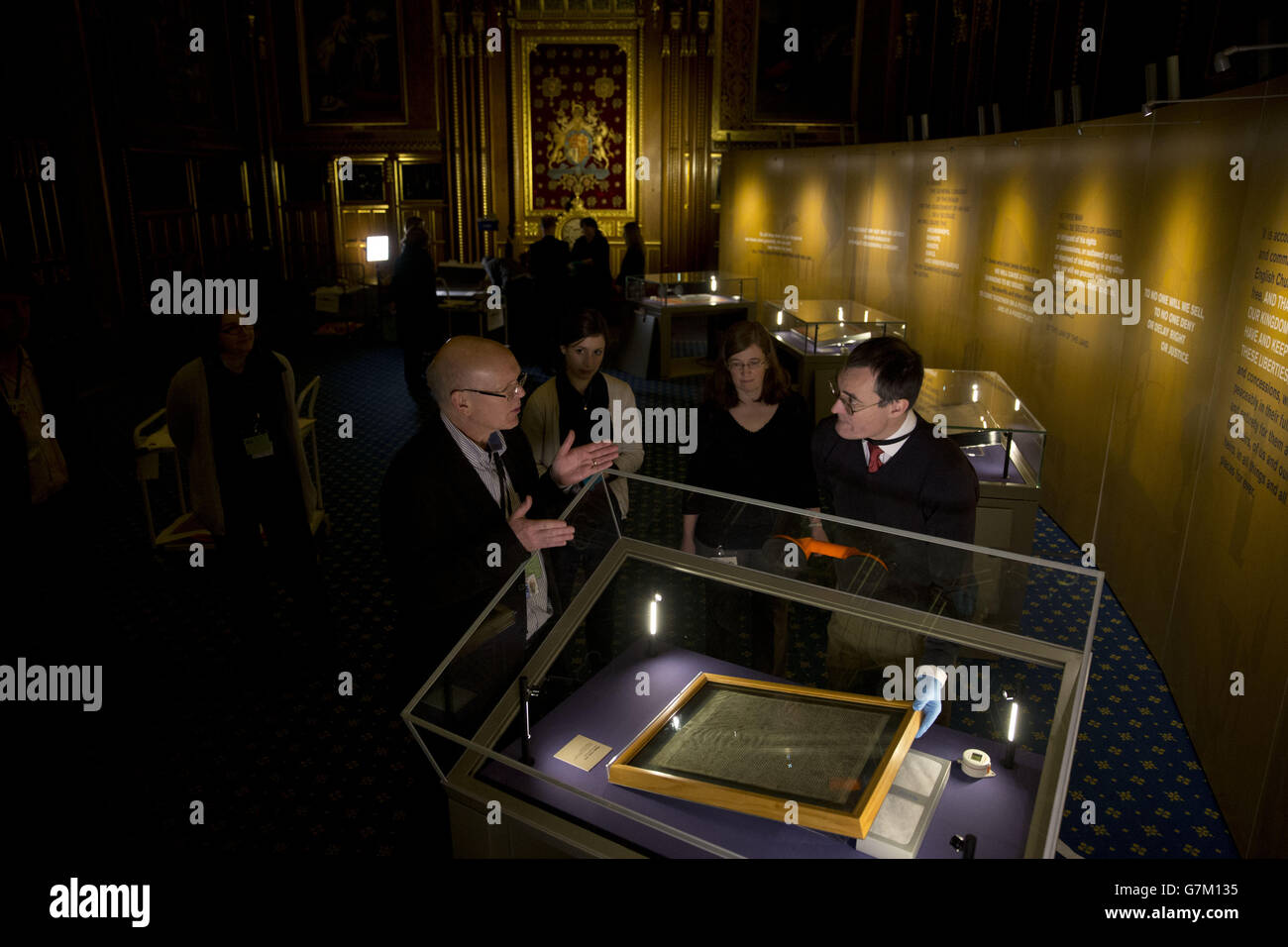 Die Salisbury Cathedral 1215 Kopie der Magna Carta wird in einem Schrank von Chris Woods (rechts), dem Direktor des National Conservation Service, installiert. Neben den anderen drei erhaltenen Originalumwingungen aus Pergament der Magna Carta anlässlich des 800. Jahrestages der Versiegelung der Magna Carta in Runnymede im Jahr 1215 im Robing Room der Queen im Houses of Parliament in London zu sehen. Stockfoto