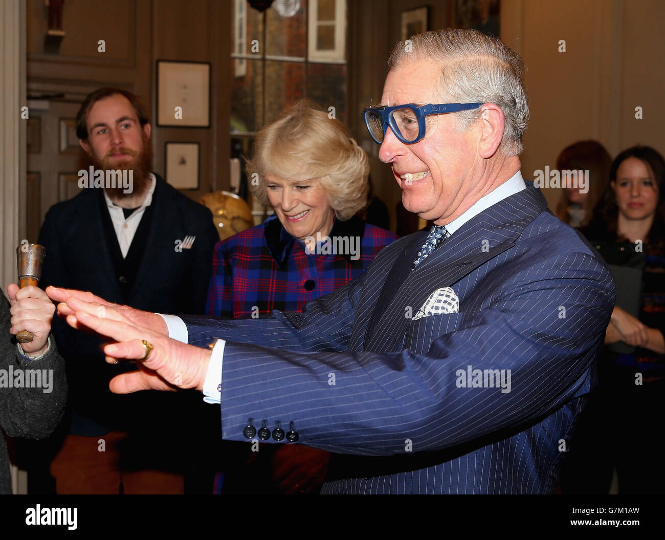 Der Prinz von Wales scherzt, dass er bei einem Besuch der Art Worker's Guild in London nicht in einer Schutzbrille sehen kann. Stockfoto