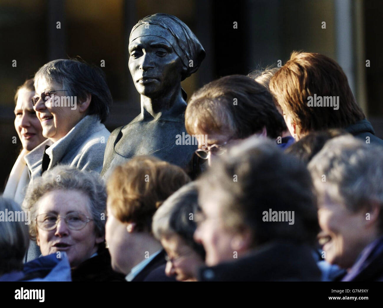 Bei einem Treffen versammelten sich Clergyfrauen um eine Statue von Frauen und Kindern, um die Opfer des Tsunami zu unterstützen. Stockfoto