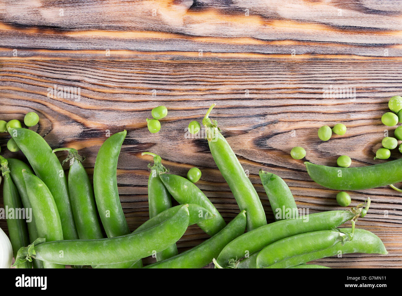 grüne Erbsen auf dem hölzernen Hintergrund. Stockfoto