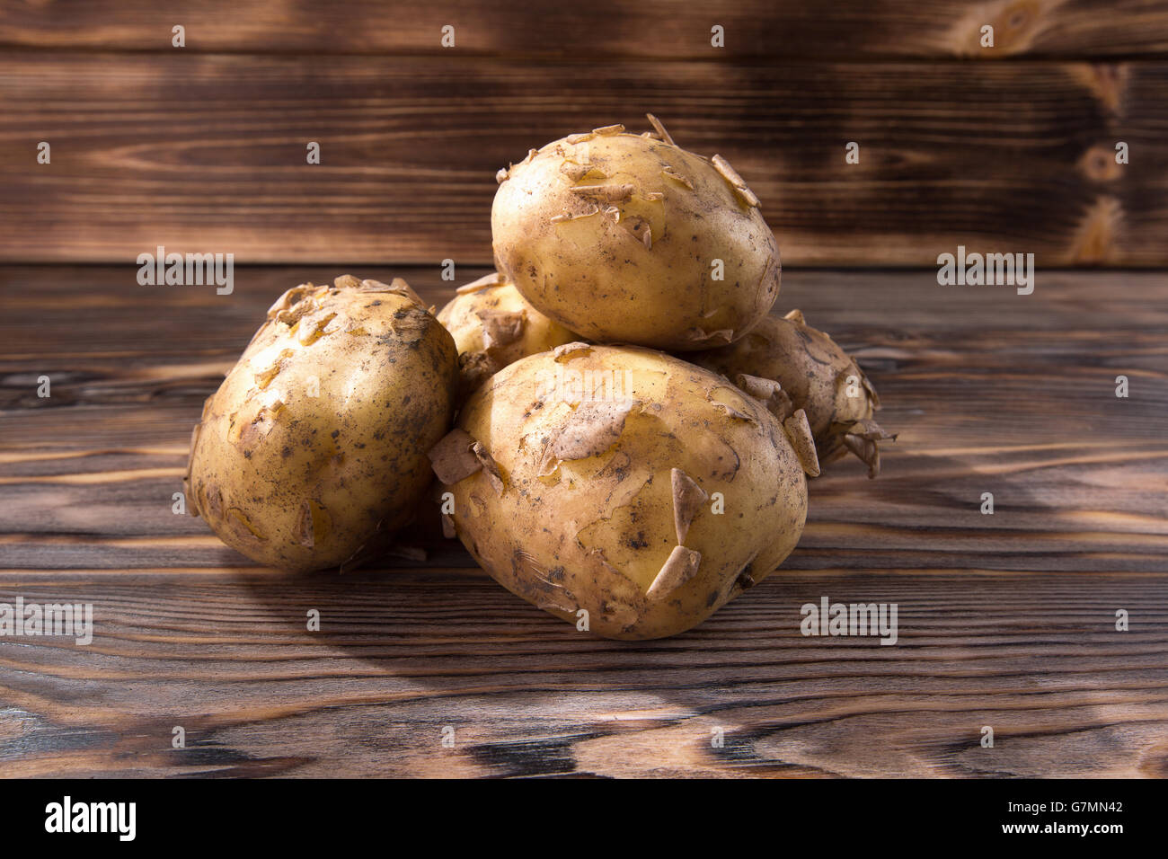 junge Kartoffeln auf dem hölzernen Hintergrund. Stockfoto