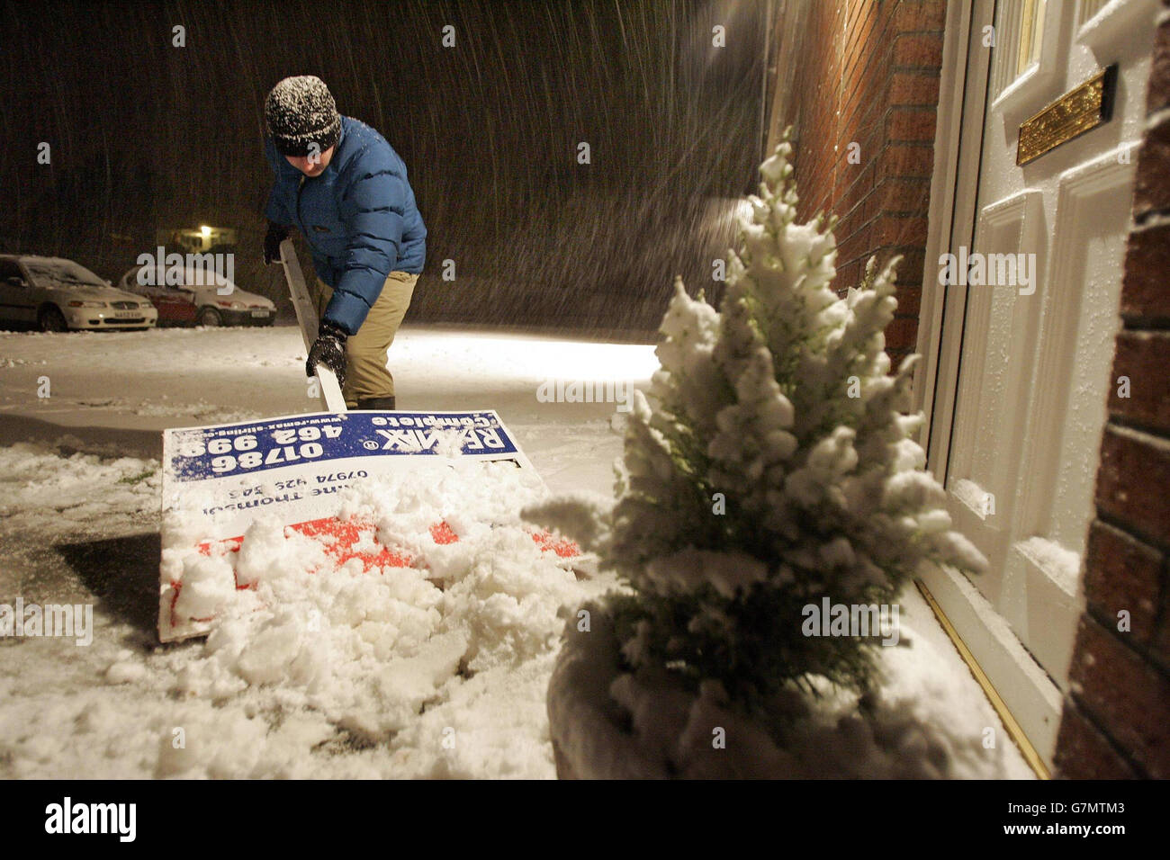 Eine Person nutzt ein for Sale-Schild, um Schnee von seiner Haustür in der Carron Bridge in der Nähe von Stirling zu räumen, während Schneestürme über Nacht Teile Schottlands fegten. Viele Teile des Landes sind aufgewacht und haben mehrere Zentimeter Schnee entdeckt. Stockfoto