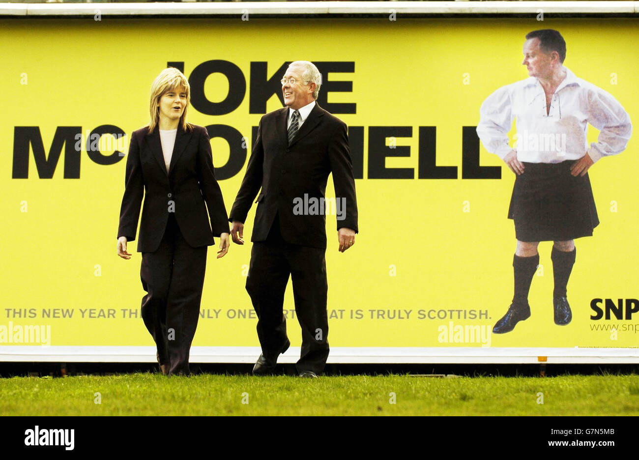Nicola Sturgeon, Vorsitzende der Scottish National Party (SNP), und Bruce Crawford, der Business-Moderator der SNP (rechts). Das Plakat macht sich über Schottlands ersten Minister Jack McConnell lustig. Stockfoto