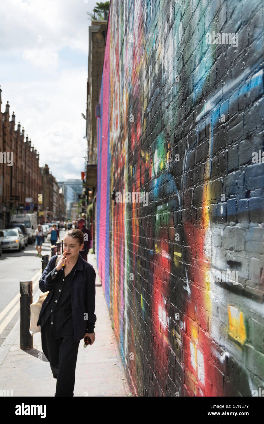 Eine Frau Rauchen auf Hanbury Street im Londoner East End. Stockfoto