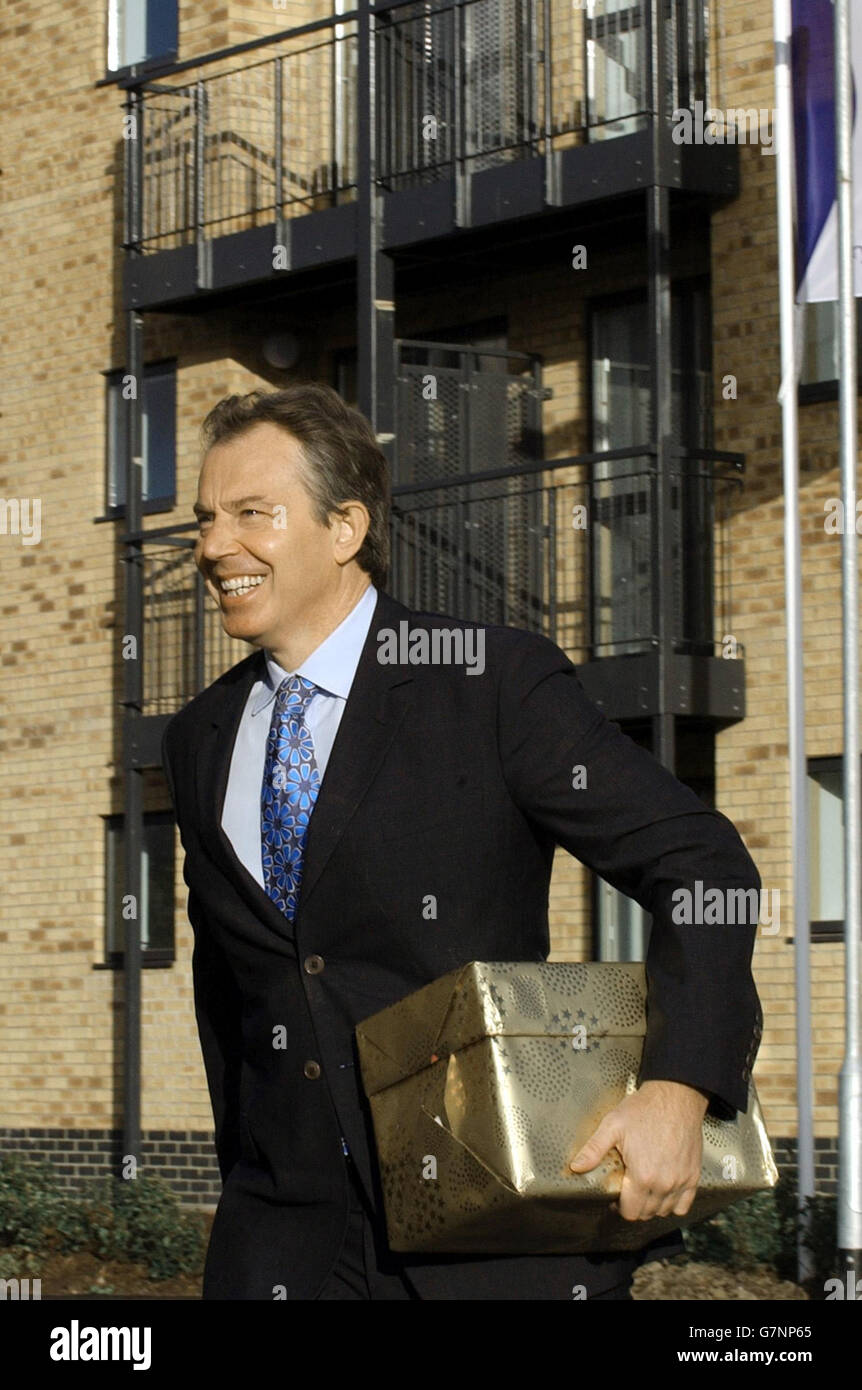 Der britische Premierminister Tony Blair kommt mit einer Teekannen und Tassen für Sharon Williams zur Hauserwärmung. Stockfoto
