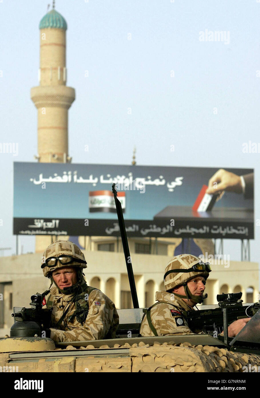Britische Soldaten, die im Hauptquartier der 4. Panzerbrigade stationiert sind, patrouillieren im Zentrum von Basra vor dem Hintergrund von Plakaten, die für die bevorstehenden Wahlen werben. Stockfoto