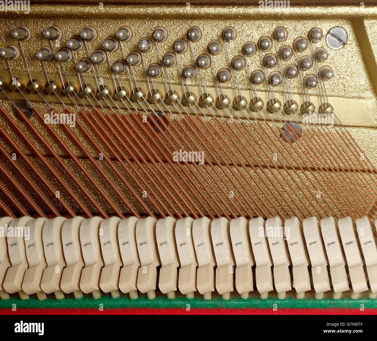Nahaufnahme des Wirkmechanismus auf ein Klavier mit Hämmern, Bass-Saiten, Pressleiste und tuning Stifte Stockfoto