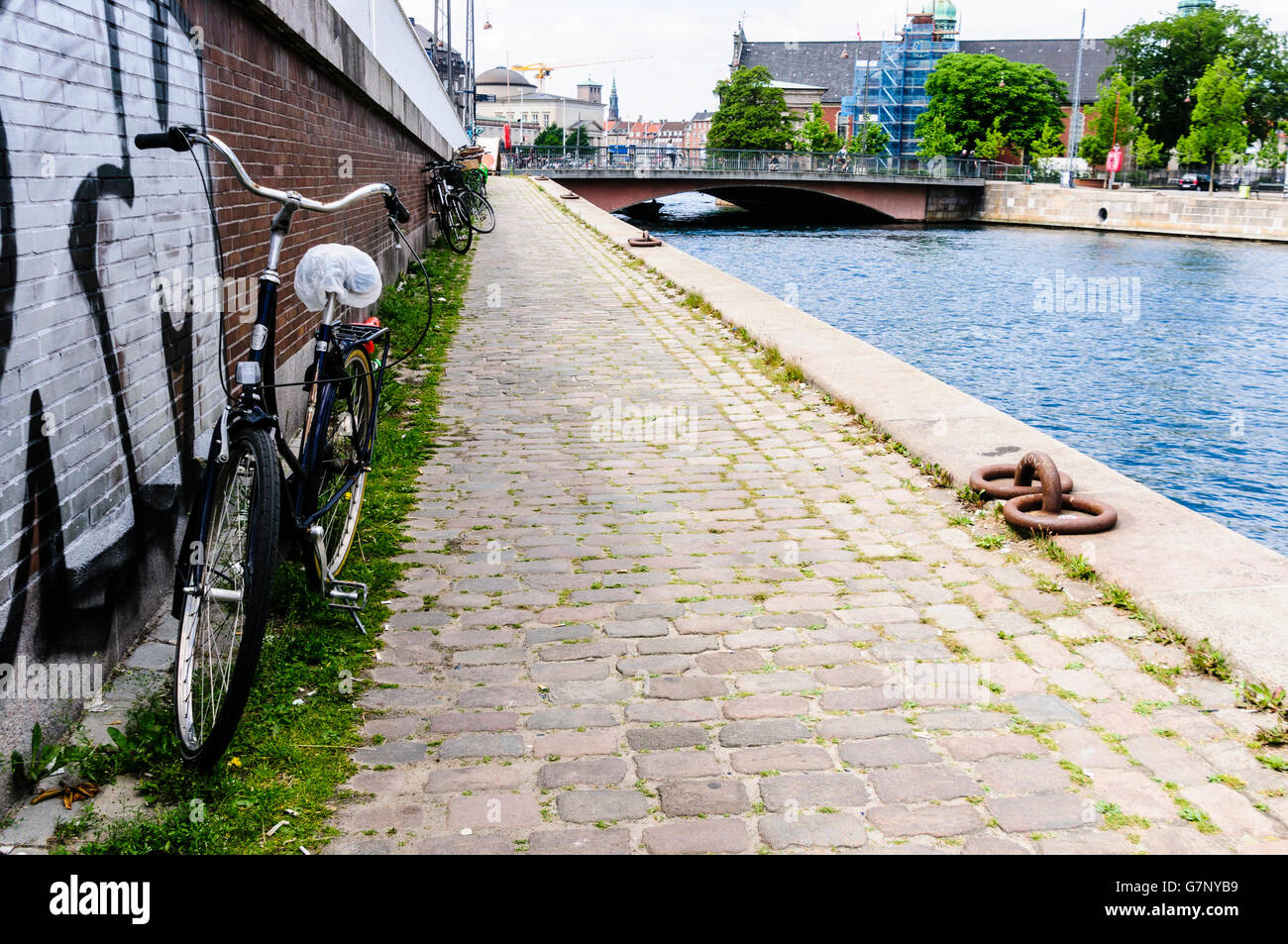 Fahrrad geparkt auf einem Weg neben einem Kanal in Kopenhagen, Dänemark Stockfoto