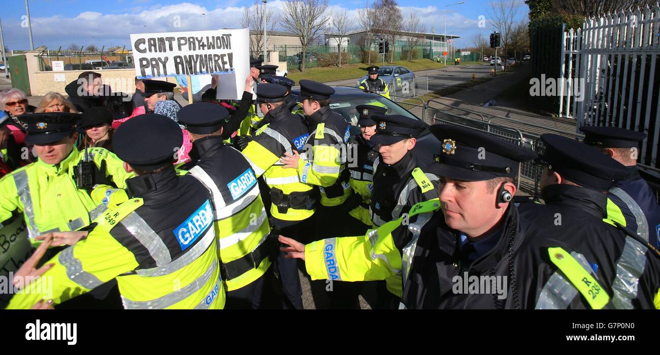 Anti-Wasser-Anklage Demonstranten stoßen mit Gardai zusammen, als Taoiseach Enda Kenny und Jobs Minister Richard Bruton heute in Bristol-Myers Squibb in Dublin für eine Investitionsankündigung ankommen. Stockfoto
