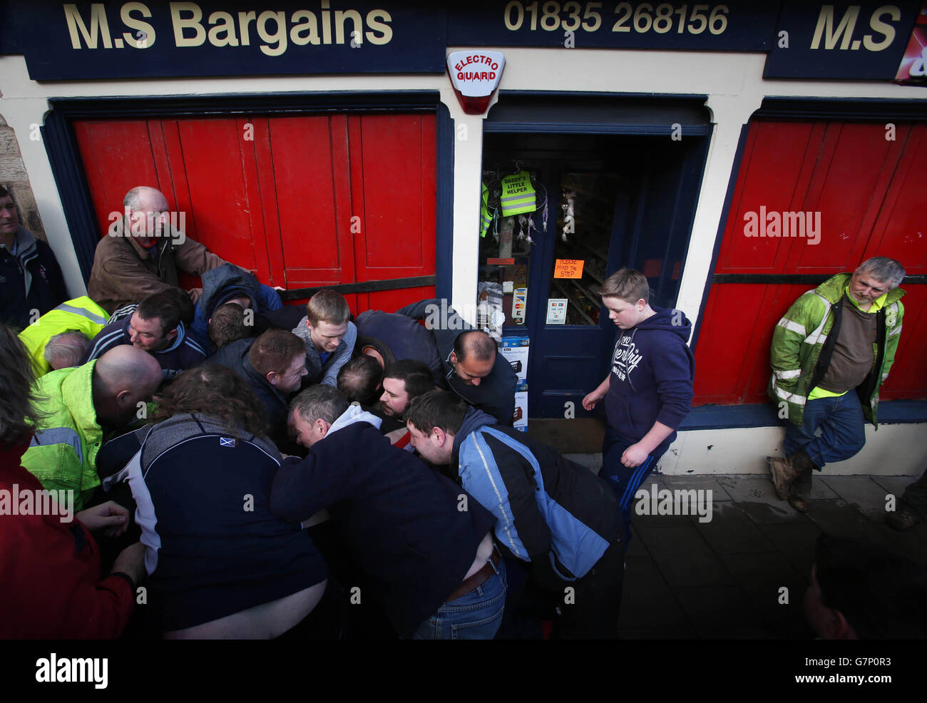 Spieler tauchen für den Ball in der Hand Ba Spiel, traditionell am ersten Donnerstag nach dem ersten Neumond in Hawick, Scottish Borders gespielt, Wo die High Street geschlossen und bestiegen wird, während zwei Teams versuchen, den oberen oder unteren Teil der Straße mit einem kleinen Ball zu erreichen. Stockfoto