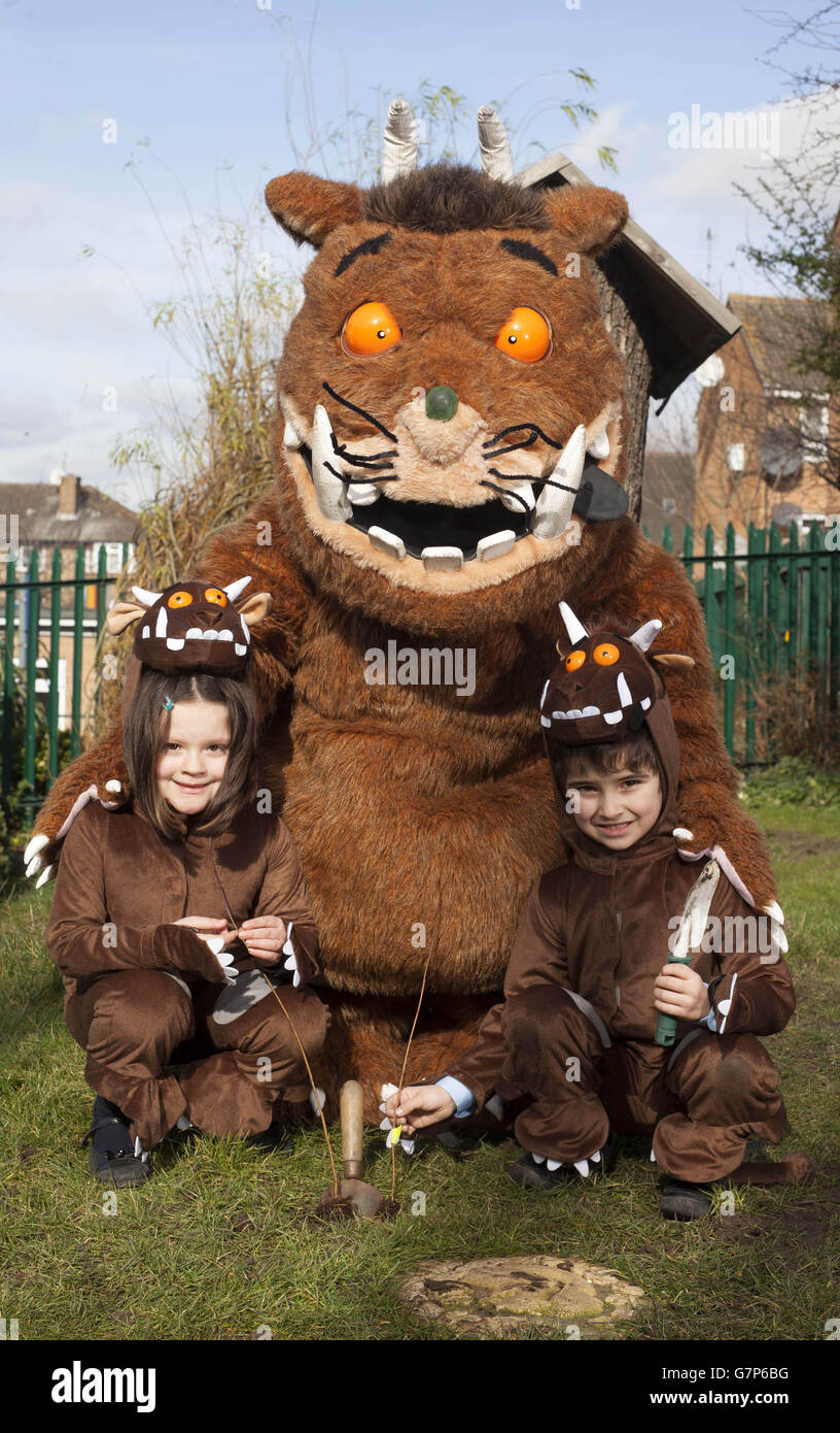 Der Gruffalo hilft den Schulkindern Lucy Bayfield (links) und Mert De Sousa Vieira von der All Saints Church of England Primary School in Barnett, Nord-London, im Rahmen der Kampagne „eine Million Bäume versprechen“ von Yorkshire Tea Bäume zu Pflanzen. Stockfoto