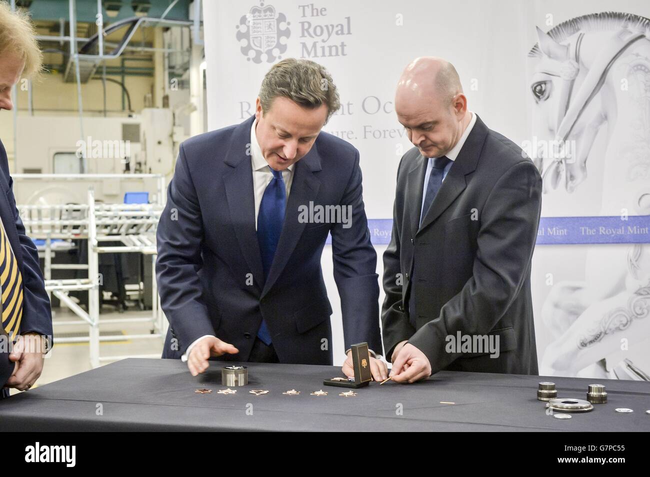 Premierminister David Cameron (links) wird von Gavin Elliott in der Royal Mint in Llantrisant, Südwales, mit Medaillen ausgezeichnet. Stockfoto