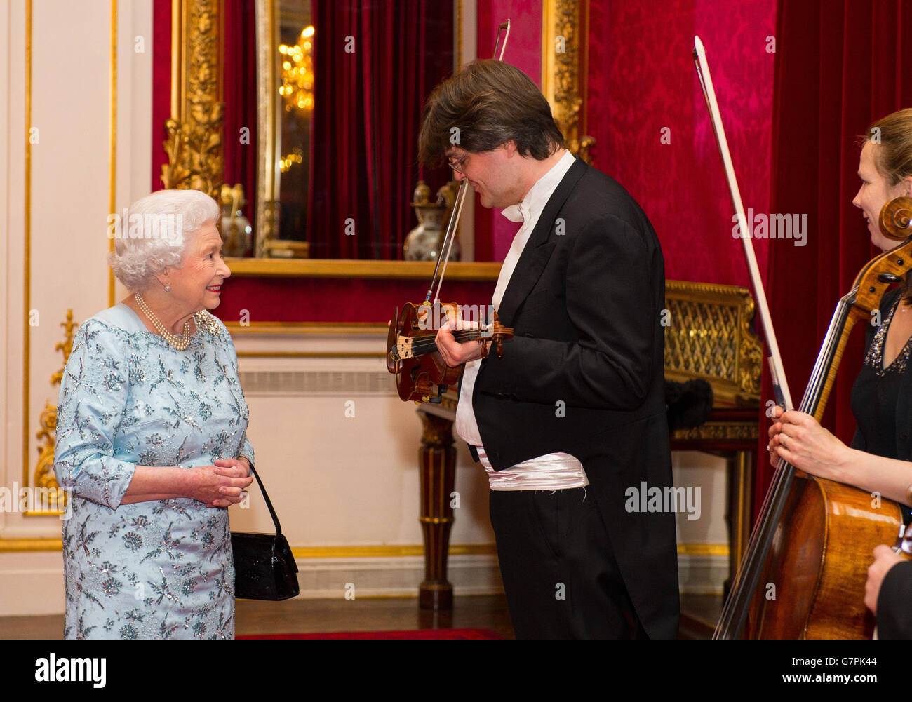 Queen Elizabeth II trifft den London Symphony Orchestra (LSO)-Geiger Roman Simovic bei einem Empfang im Buckingham Palace, London, um den Abschluss der "Moving Music"-Kampagne und die lange Assoziation von Michael Tilson Thomas mit dem LSO zu markieren. Stockfoto