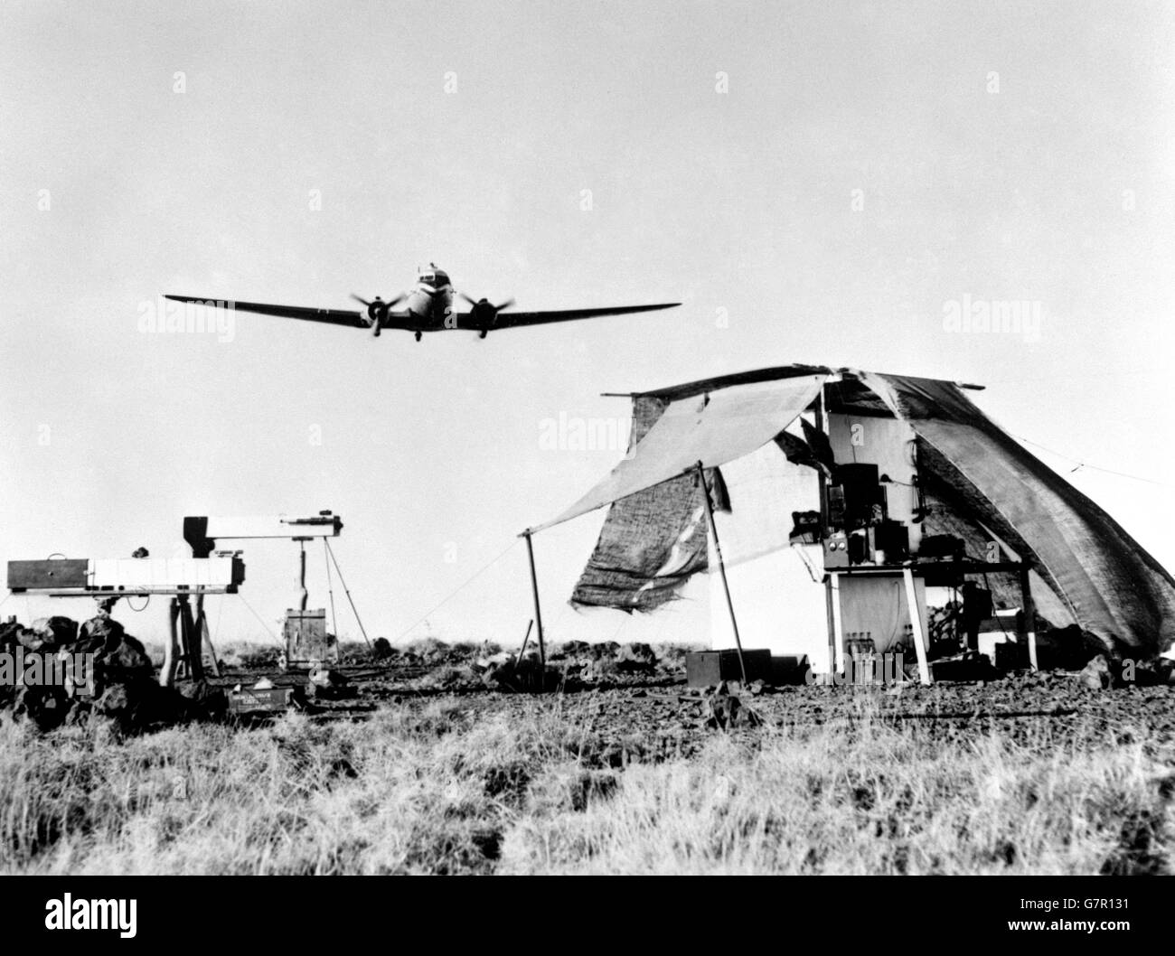 Ein patrouillierender RAAF Dakota fliegt über die Kamera-Beobachtungsposten, komplett mit mobiler Dunkelkammer eingerichtet. Das Lager war ein Objekt von Interesse für die Männer, die an dem Atomtest beteiligt waren. Konteradmiral A. D. Torlesse machte eine besondere Reise in seinem eigenen Flugzeug, um es zu sehen. Sie fotografierten die Explosion der ersten britischen Atomwaffe, die auf den Monte Bello-Inseln vor Australien explodiert war. Die Kameras wurden in grober Reichweite aufgestellt, 55 Meilen vom Zentrum des Atomgebiets entfernt. Stockfoto