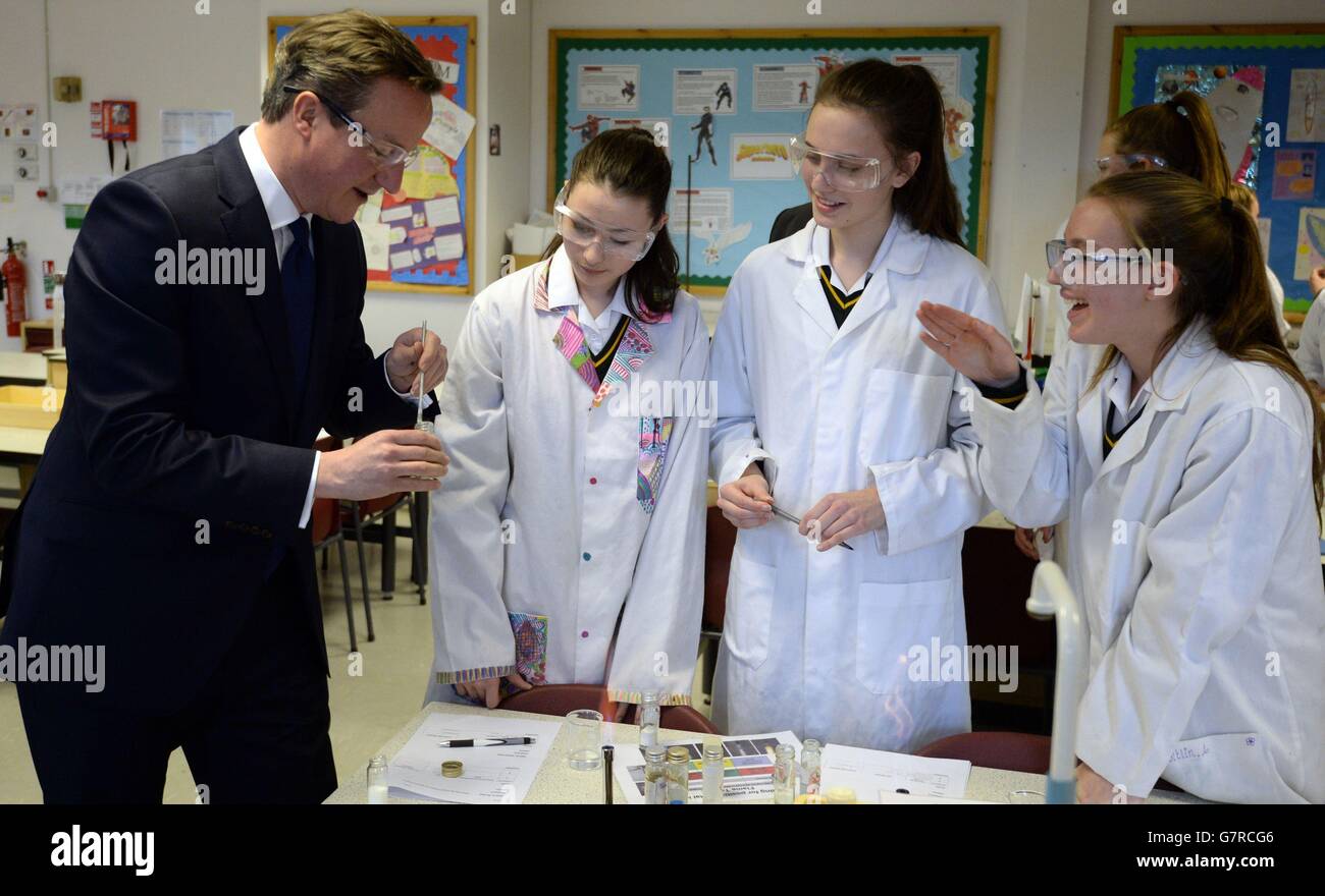 Premierminister David Cameron trifft Schüler und sieht einen Wissenschaftsunterricht bei einem Besuch der Green School for Girls im Westen Londons mit Bildungsminister Nicky Morgan, wo er verkündete, dass die Regierung die Zahl der freien Schulen erhöhen werde, wenn sie die Parlamentswahlen im Mai gewinnen würden. Stockfoto