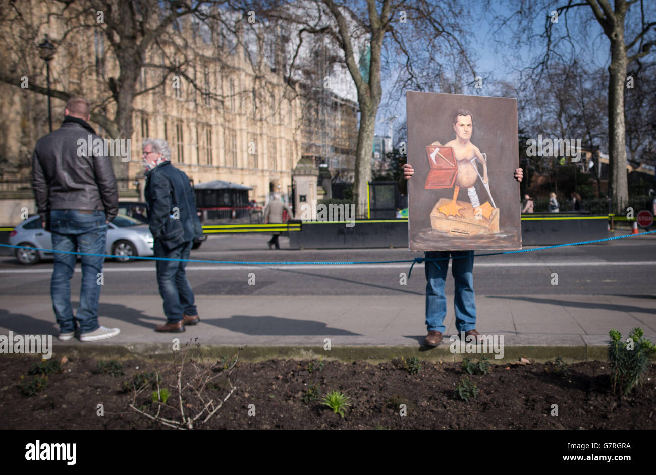 Der satirische Künstler Kaya Mar zeigt sein neuestes Gemälde, während sich Journalisten, Politiker und Demonstranten vor dem Londoner Parlamentsgebäude auf Abingdon Green versammeln, nachdem Bundeskanzler George Osborne die Haushaltserklärung abgegeben hat. Stockfoto
