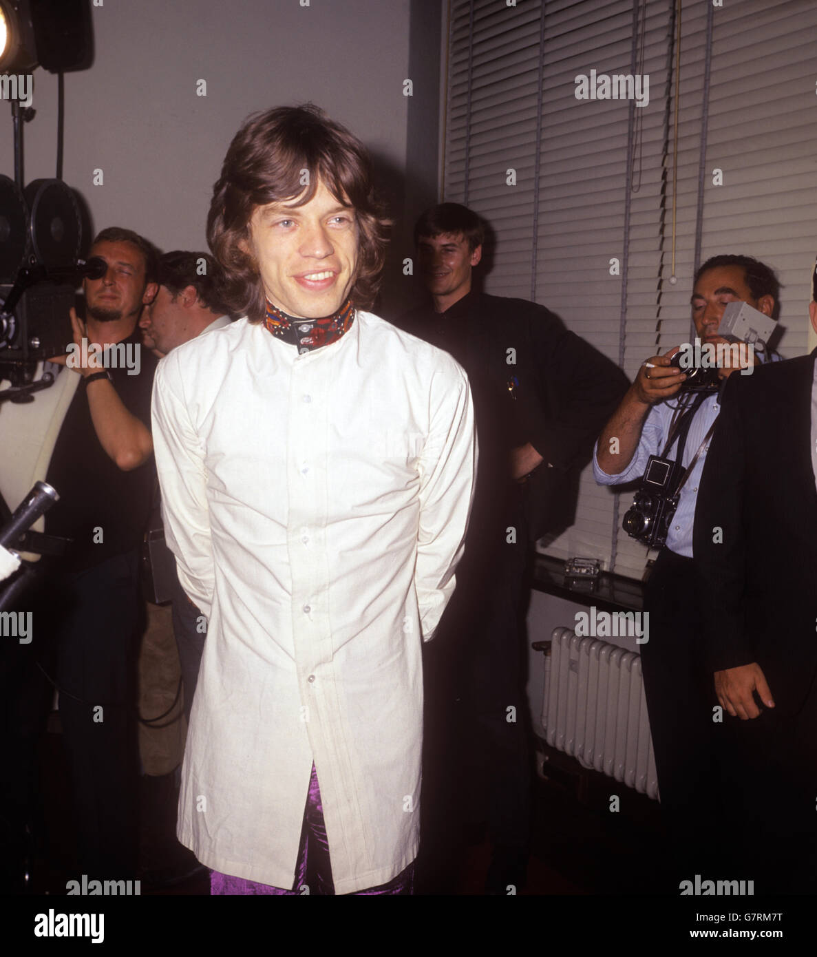 Mick Jagger, von den Rolling Stones, in lila Satinhose, off-white Hemdjacke mit gesticktem roten, gelben und grünen Kragen und Manschette, auf einer Londoner Pressekonferenz, wo er ankündigte, seine Drogenüberzeugung sei niedergeschlagen worden. Stockfoto