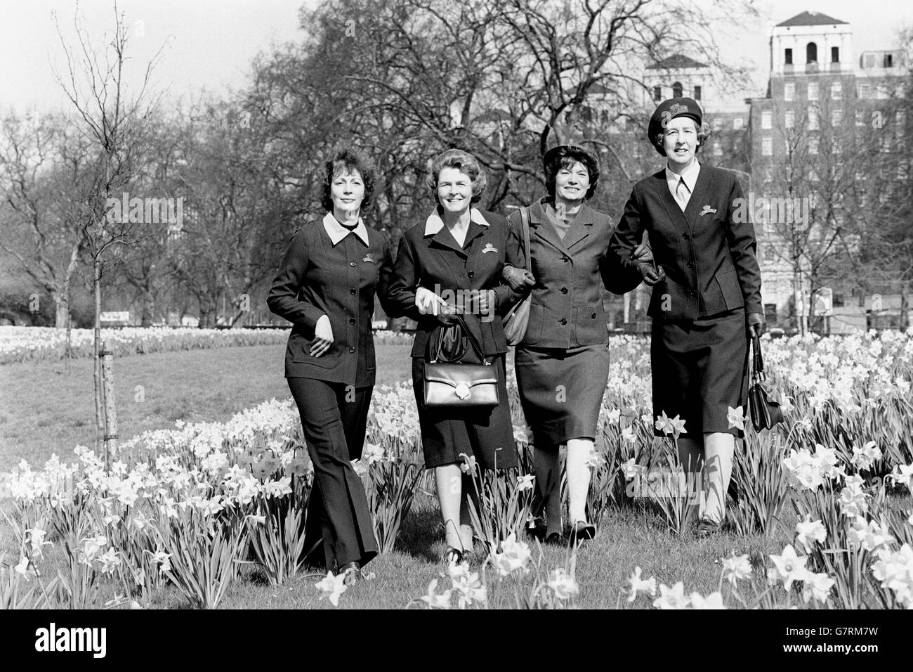 Im Gegensatz zur alten Uniform (zweite rechts) stehen Versionen der neuen Uniform, die vom Royal Voluntary Service der Frauen ("die Frauen in Grün") zur Feier des 40. Jahrestages der WRVS übernommen wird. Die neue Uniform, noch grün, ist eine Mix-Match-Serie von Kleidern, Jacken, Röcken, Mänteln und Hosenanzügen. Unter den Narzissen im Hyde Park, London, sind WRVS Mitglieder (l-r) Anita Hurwitz, von Arkley, in einem Hosenanzug, Connie ward, von Tonbridge, in Kleid und Jacke, Kaye Barker, von Bickley, in der alten Uniform, und Daphne Maisey, von Wallington, in Rock, Hemd und Jacke. Stockfoto