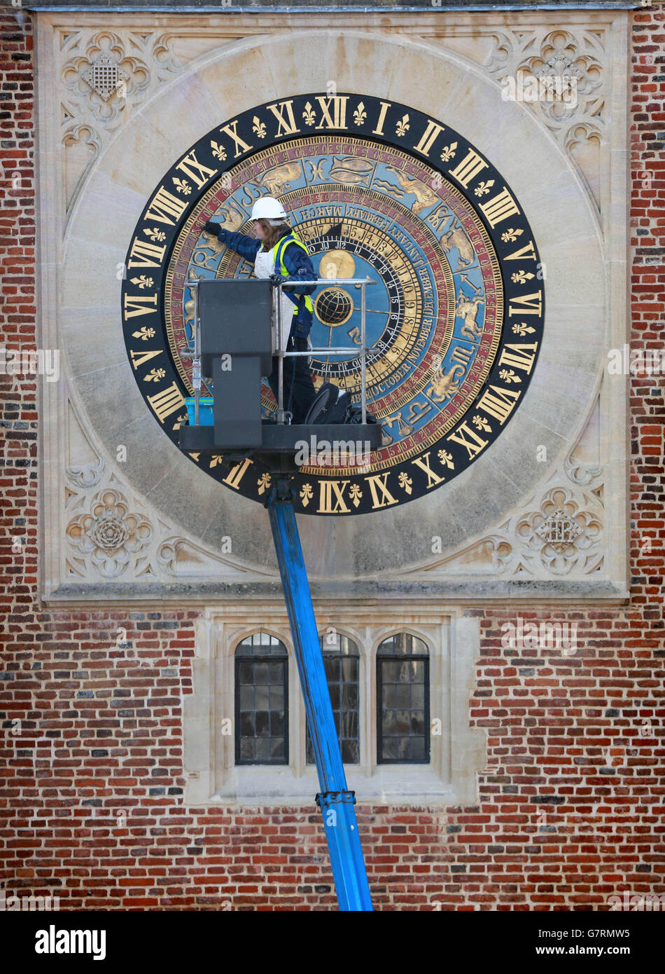 Claire McDermott putzt das Gesicht der astronomischen Uhr im Hampton Court Palace in East Molesey, Surrey, als Vorbereitung auf die Feierlichkeiten zum 500. Jahrestag des Palastes an Ostern. Stockfoto