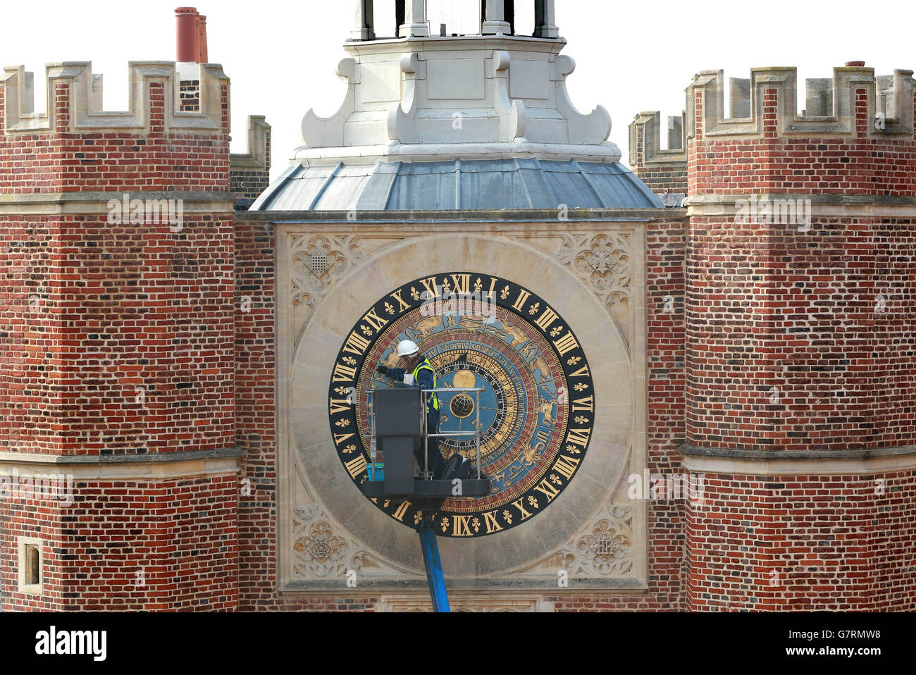 REDAKTIONELLE VERWENDUNG NUR Claire McDermott reinigt das Gesicht der astronomischen Uhr im Hampton Court Palace in East Molesey, Surrey, zur Vorbereitung auf die Feierlichkeiten zum 500. Jahrestag der Paläste an Ostern. Stockfoto