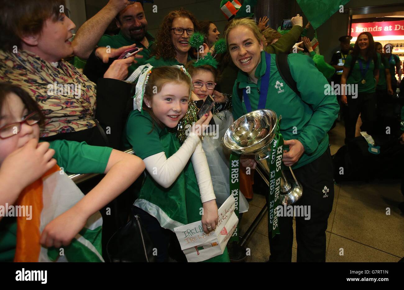 Irlands Rugby-Kapitän Niamh Briggs hält die Six Nations-Trophäe, während sie mit Fans feiert, als das Team am Flughafen Dublin ankommt, nachdem es die Six Nations-Trophäe bei einem 73-3-Sieg über Schottland in Glasgow gewonnen hat. Stockfoto