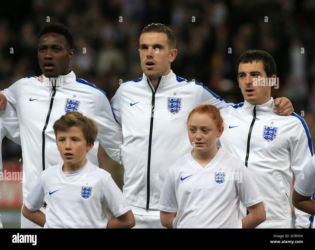 Die Engländer Danny Welbeck, Jordan Henderson und Leighton Baines singen die Nationalhymne vor dem UEFA 2016 Qualifying, Gruppe E Spiel im Wembley Stadium, London. Stockfoto