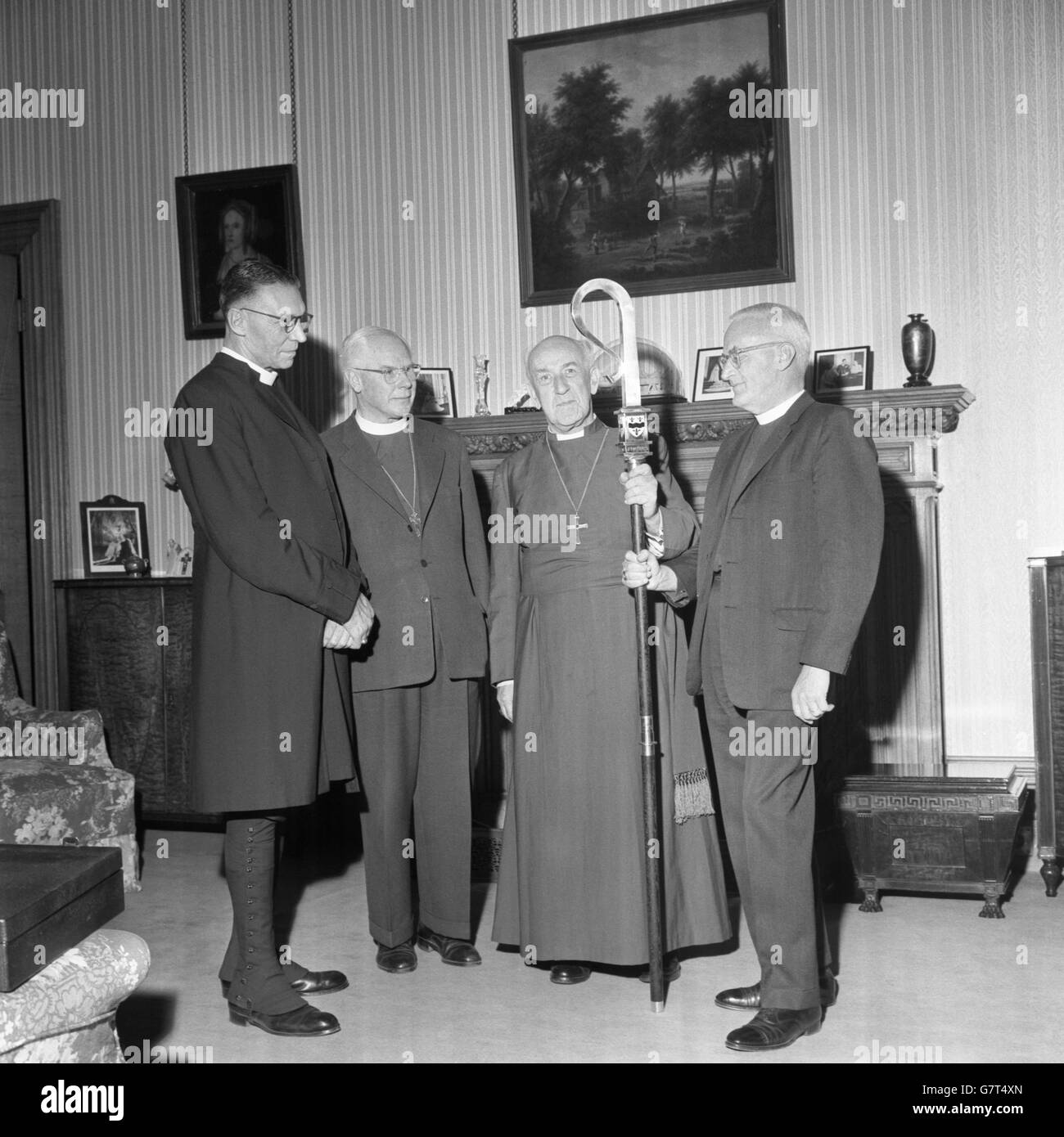 Der anglikanische Exekutivdirektor, Bischof Stephen E. Bayne (r) überreicht dem Erzbischof von Canterbury, Dr. Geoffrey Fisher, im Lambeth Palace, London, einen feinen silbernen Bischofsstab als Geschenk anlässlich seines bevorstehenden Ruhestands von den 33 Bischöfen und Erzbischöfen, die seine Mitbürger der anglikanischen Gemeinschaft sind. Der Bischofsstab, oder Hirtenstab, ist das charakteristische Emblem eines Bischofssitzes, das von ihm in Prozession getragen wird oder wie er an der Anbetung und dem Leben der Kirche teilnimmt. Ebenfalls abgebildet sind Erzbischof Beecher aus Ostafrika und Erzbischof Madnnes von Jerusalem. Stockfoto