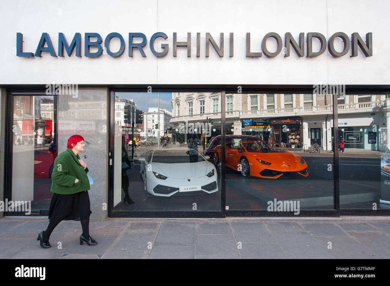 Eine Frau geht an einem Lamborghini-Händler in Kensington, West London, vorbei. Mehr als eine halbe Million älterer Sparer werden ab heute mit dem Beginn eines neuen Rentensystems des 21. Jahrhunderts radikale neue Freiheiten erhalten. Stockfoto