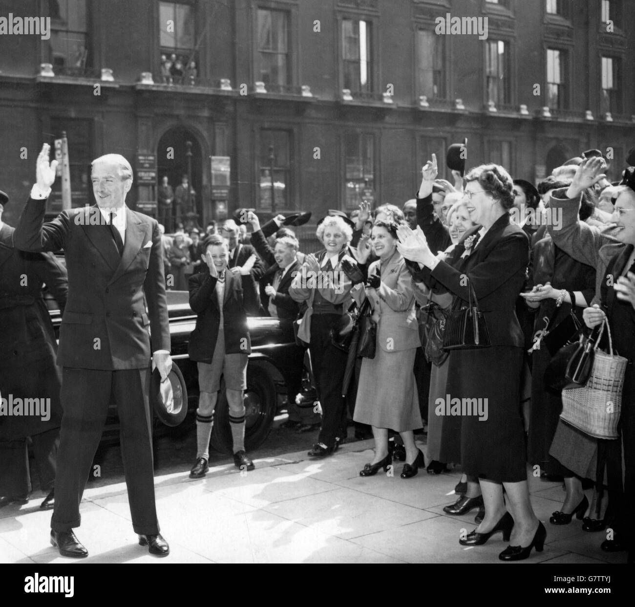 Sir Anthony Eden, Premierminister und Führer der Konservativen Partei, winkt der applaudierenden Menge zu, als er am Hauptquartier der Tory Party im Abbey House, Westminster, London, ankommt, nachdem seine Partei bei den Parlamentswahlen eine Mehrheit erhalten hatte. Stockfoto