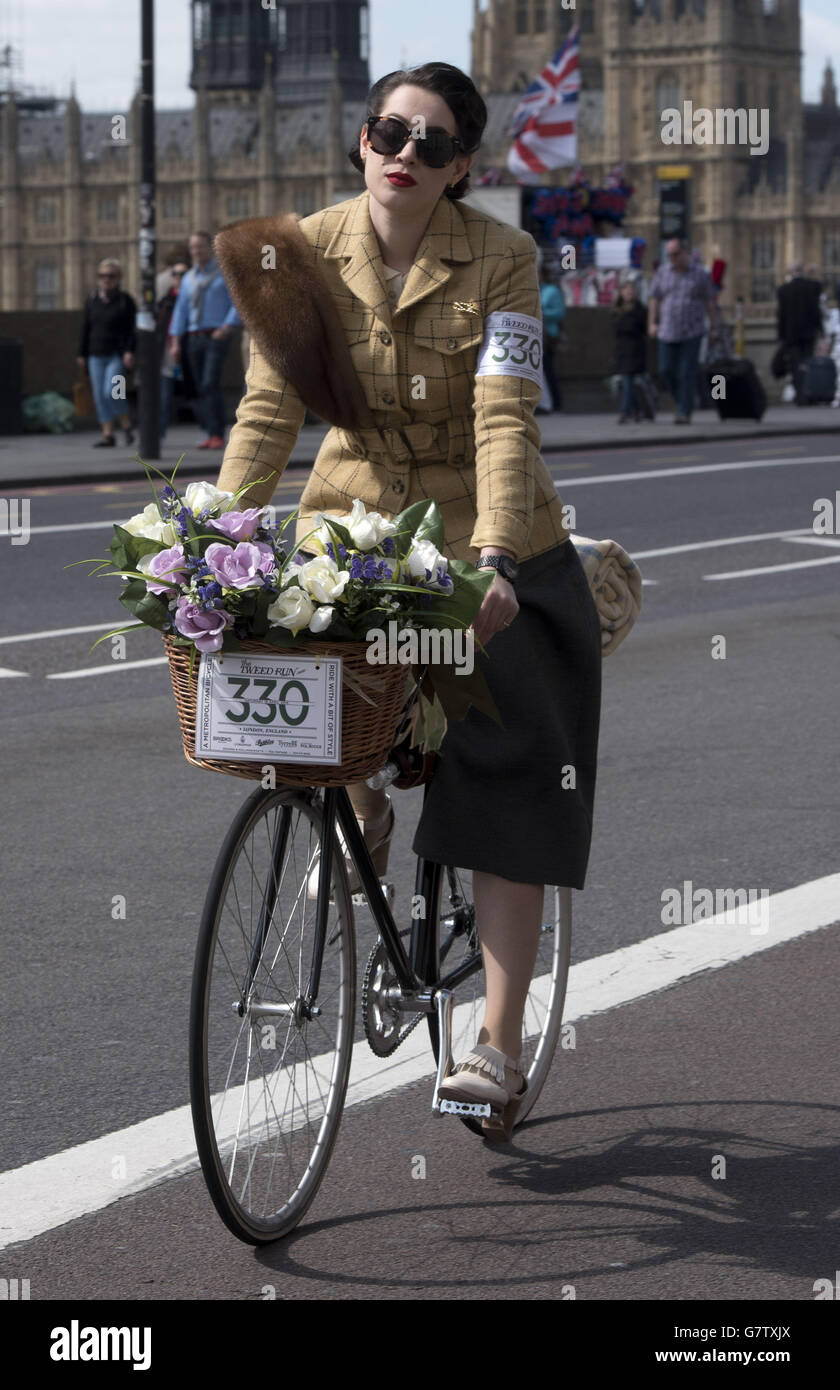 Eine getweete Radfahrerin fährt über die Westminster Bridge, London, während sie am siebten jährlichen London Tweed Run teilnimmt. Stockfoto Eine getweete Radfahrerin fährt über die Westminster Bridge, London, während sie am siebten jährlichen London Tweed Run teilnimmt. Stockfoto