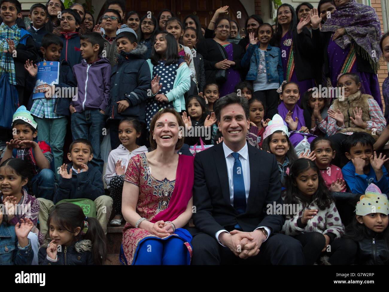 Der Gewerkschaftsführer Ed Miliband und seine Frau Justine (vorne) treffen Hindu-Anhänger im Shree Swaminarayan Temple in Willesden Green, London, wo sie an einer Feierstunde teilnahmen und Aktivitäten im Kindergarten beobachteten. Stockfoto