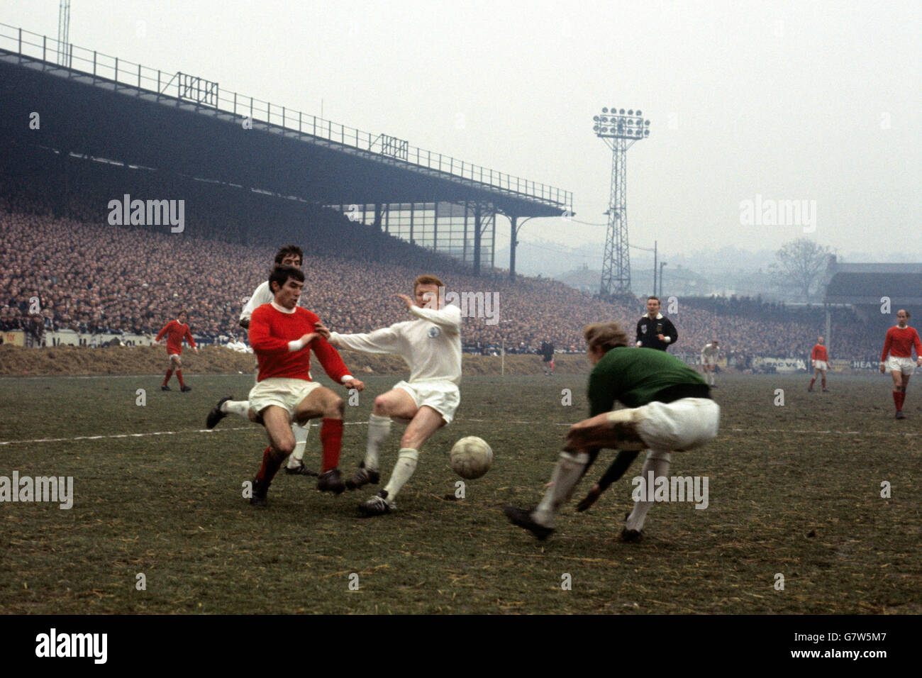 Leeds United Torwart Gary Sprake (r) sammelt den Ball, als Tony Dunne (l) von Manchester United versucht, sich an Billy Bremer von Leeds United zu vorbeidrängen (c) Stockfoto