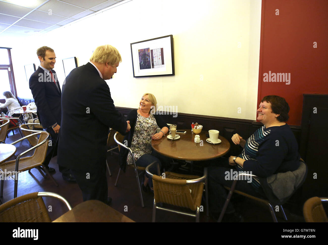 Der Bürgermeister von London Boris Johnson mit konservativem Kandidaten für Kingston und Surbiton James Berry (links) im Gespräch mit den Gästen während des Wahlkampfes in New Malden im Südwesten Londons. Stockfoto