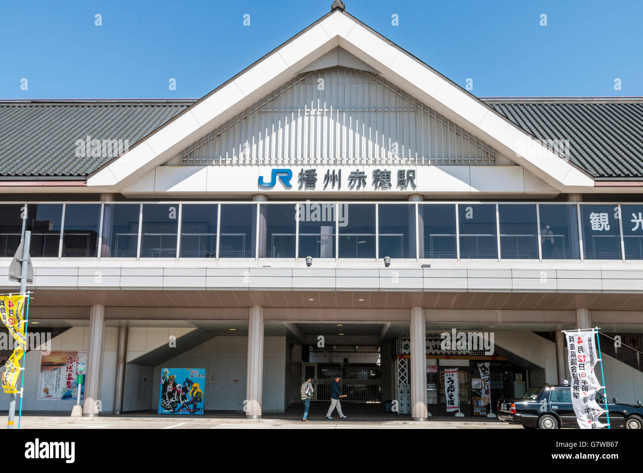 Japan, Ako. JR. Japanische Bahnhofsgebäude mit JR-Logo und Kanji Name auf der Vorderseite. Strahlend blauer Himmel hinter sich. Stockfoto